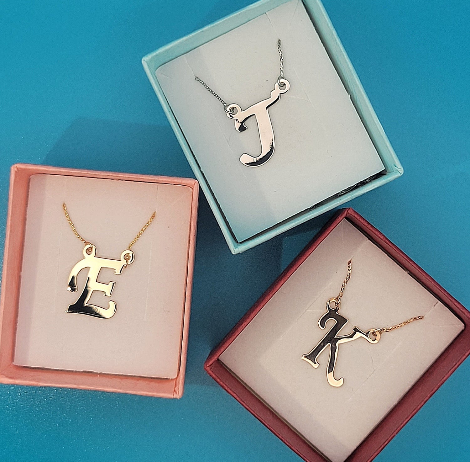 3 color boxes: Pink, Blue, Red with gold initials: E-yellow, J-white, K-rose. Image 2of4 main page