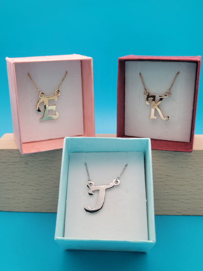 Colorful jewelry boxes: pink with gold 'E', blue with white gold 'J', red with rose gold 'K'